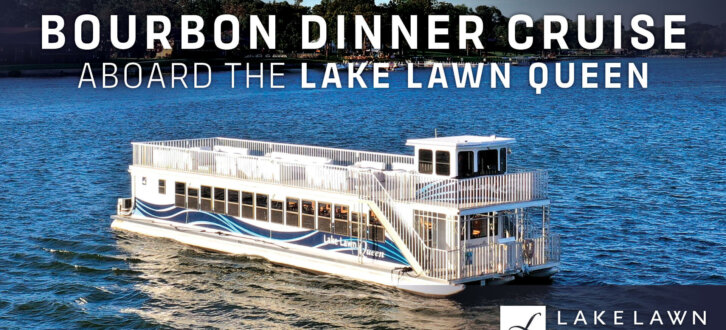 Bourbon Dinner Cruise on the Lake Lawn Queen. We see the Lake Lawn Queen sitting on the sparkling waters of Delavan Lake. The Boat is white and large.